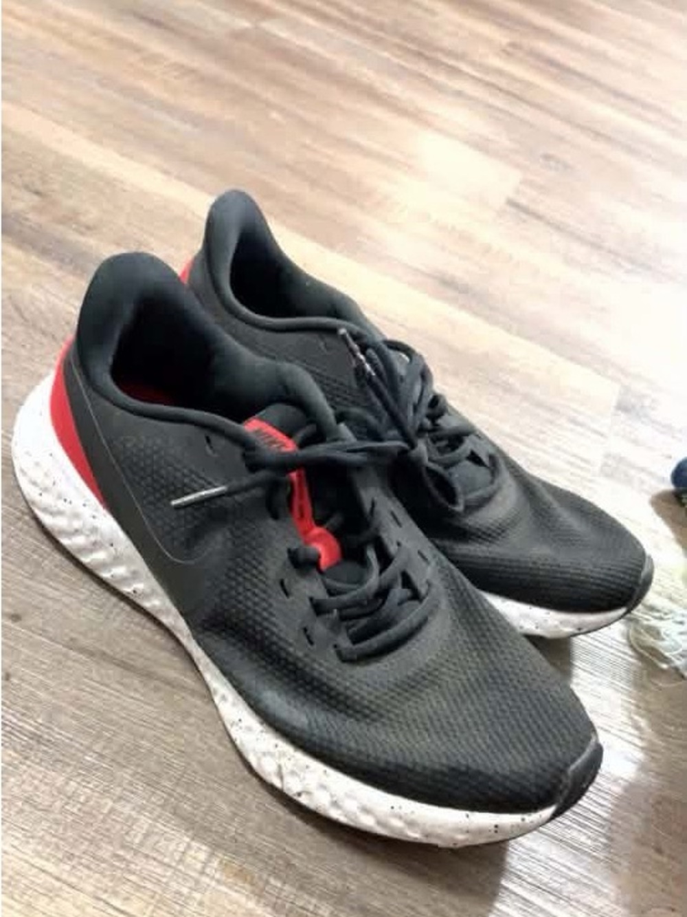 Nike Black Athletic Running Shoes with Red Accent and Speckled White Midsole
